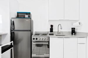 a kitchen with a stainless steel refrigerator and a stove at Private modern studio w pool - Steps to the beach in Deerfield Beach