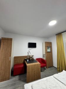 a hotel room with a bed and a desk and a tv at La Romică in Mediaş