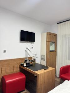 a hotel room with a desk and a red chair at La Romică in Mediaş +32 photos