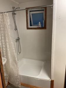 a bath tub with a shower curtain in a bathroom at Refugio Jemmy Button in Puerto Williams +30 photos
