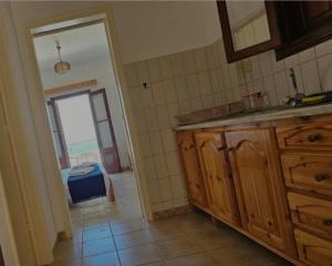a kitchen with a sink and a door to a room at Louis Studios and Apartments Melitsaha Beach in Kalymnos