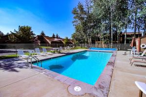 a swimming pool with lounge chairs and a fence at McCall Golf Condo - Pool Courts & Patio in McCall
