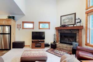 a living room with a fireplace and a flat screen tv at McCall Golf Condo - Pool Courts & Patio in McCall