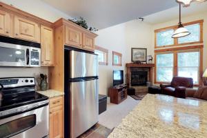 a kitchen with a stainless steel refrigerator and a living room at McCall Golf Condo - Pool Courts & Patio in McCall +28 photos