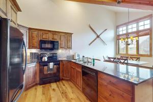 a kitchen with wooden cabinets and a stainless steel refrigerator at Big Sky Bliss in Big Sky