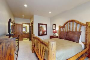 a bedroom with a large wooden bed and a bathroom at Big Sky Bliss in Big Sky