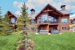 a large wooden house with a green yard at Big Sky Bliss in Big Sky