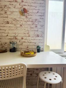 a white table in a kitchen with a white brick wall at Studio cosy in Valenciennes +6 photos