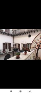 ein Gebäude mit einem Innenhof mit Topfpflanzen darauf in der Unterkunft Moon Light Hostel in Palermo
