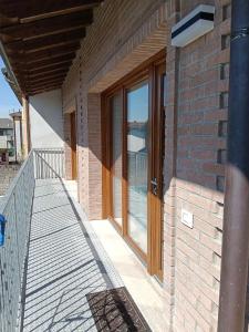 a brick building with glass doors and a balcony at NaturalmenteLucia in Cologno al Serio