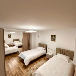 a hotel room with three beds in it at In The House Hostel in Prishtinë