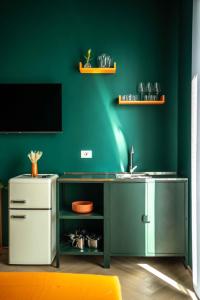 a kitchen with a sink and a green wall at MR Suites Bergamo in Seriate