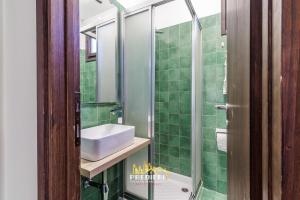 a bathroom with a sink and a shower with green tiles at Sest0la Centro Loft con Vista sul Paesaggio in Sestola +17 photos