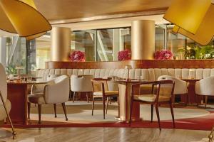 ein Restaurant mit Tischen und Stühlen in einem Raum in der Unterkunft The Berkeley, Maybourne in London