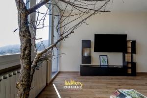 a living room with a tv and a tree at Sest0la Centro Loft con Vista sul Paesaggio in Sestola