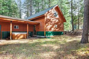 a cabin in the woods with a tree at Rustic-Modern Cabin with Hot Tub Access in McCall