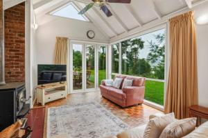 a living room with a couch and a tv at Waitati Retreat in Waitati