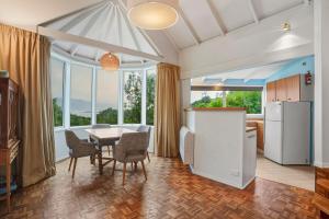 a kitchen and dining room with a table and chairs at Waitati Retreat in Waitati
