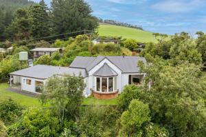 an aerial view of a white house with trees at Waitati Retreat in Waitati
