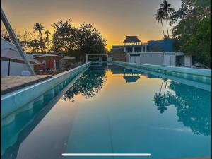 a swimming pool with a sunset in the background at Casa Bonassola, Barra de Navidad in Barra de Navidad