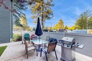 a patio with a table and chairs and a grill at Downtown McCall Condo with Balcony & Views in McCall