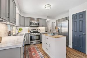 a kitchen with stainless steel appliances and a blue door at Spacious Northfield 4BR Escape near Cuyahoga Valley in Northfield +34 photos