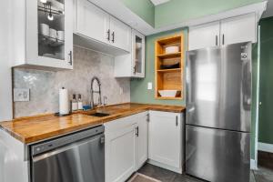 a kitchen with white cabinets and a stainless steel refrigerator at The Paper Plane Pool - Sauna - Poker Room - Sleeps 8 in Dayton
