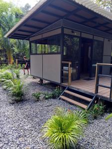 a small building with a person sitting on a porch at Glamping las palmas in Nimaima
