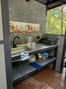 a kitchen with a sink and a counter top at Glamping las palmas in Nimaima