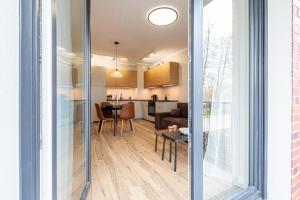 a kitchen and living room with a table and a dining room at Tarasy Bernardyńskie 44 in Kalisz +3 photos