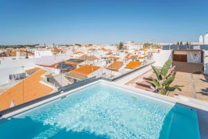 een zwembad op het dak van een gebouw bij Authentic Tavira Hotel in Tavira