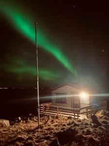 a cabin with the aurora in the sky at Vestra-Fíflholt cabin 1 in Hvolsvöllur
