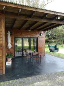 a patio with chairs and a table in a cabin at Cabañas La Mansa, Casa grande in Balcarce +4 photos
