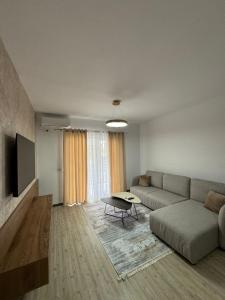 a living room with a couch and a table at Poshi Apartment in Krujë