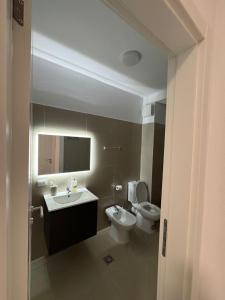 a bathroom with a toilet and a sink and a mirror at Poshi Apartment in Krujë