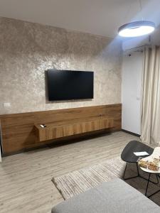 a living room with a flat screen tv on a wall at Poshi Apartment in Krujë +6 photos