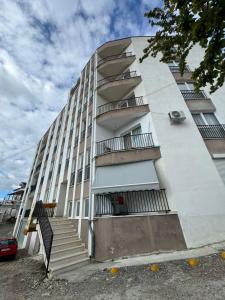 a white building with stairs in front of it at Poshi Apartment in Krujë