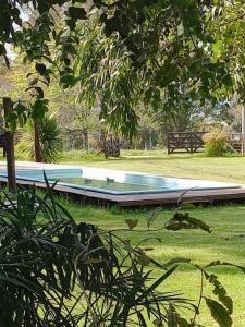 a swimming pool in a park with a tree at Cabañas La Mansa, Casa grande in Balcarce