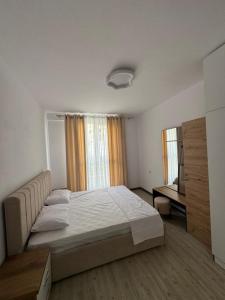 a bedroom with a large bed and a desk at Poshi Apartment in Krujë