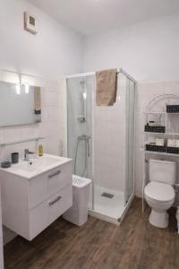 a bathroom with a shower and a sink and a toilet at Gîte Le Repos de Merlin - Paimpont, Forêt de Brocéliande in Paimpont