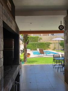 an outdoor patio with a fireplace and a table and chairs at Espectacular Casa con pileta y jacuzzi in San Juan