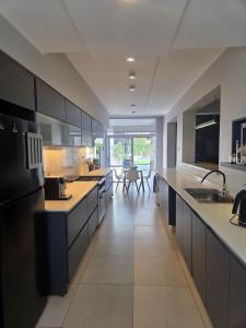 a large kitchen with black and white counter tops at Espectacular Casa con pileta y jacuzzi in San Juan