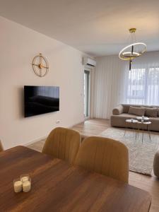 a living room with a table and a couch at Inviti Apartments in Gjakove