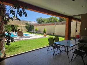 a patio with a table and chairs and a yard at Espectacular Casa con pileta y jacuzzi in San Juan