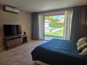 a bedroom with a bed and a flat screen tv at Espectacular Casa con pileta y jacuzzi in San Juan