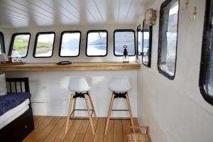 two stools in a small room with windows at Captains Room - Havborg in Hvannasund