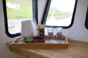 a wooden shelf with three glasses and a coffee maker at Captains Room - Havborg in Hvannasund