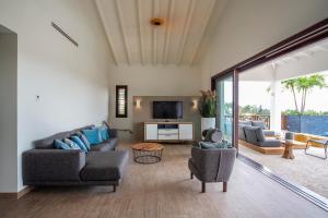a living room with two couches and a tv at Blue Bay Exclusive in Banda Abou