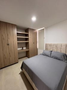a bedroom with a large bed and wooden cabinets at Ruby Suites I Apto en Valledupar I Lujo y Confort I Aire en todas las habitaciones in Valledupar +77 photos