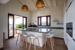 a kitchen with a large island with stools at Blue Bay Exclusive in Banda Abou